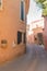 A narrow street in the beautiful French village of Roussillon, where the buildings are made with colorful