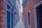 A narrow street with brick houses and Windows with bars