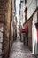 The narrow street in the city with old buildings receding into the distance