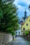 A narrow street with cobbled stones, gardens and high garden walls in Southern Germany