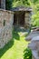 Narrow street covered with grass between old stone walls