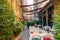 A narrow street half lined with restaurant tables. Summer area of the restaurant on a narrow street