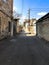 Narrow street, lane, tunnel with old houses, buildings on the sides in a poor area of the city, slums. Vertical photo