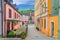 Narrow street of Loket town with colorful traditional typical buildings, street flowers and Column of the Holy Trinity