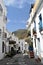 Narrow street with a mosaic in the middle,blue pots ...and scooters, Frigiliana - Spanish white village Andalusia