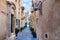 Narrow street in Rabat, Malta with residential buildings at noon.
