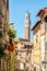 Narrow street in Siena, view on the Torre del Mangia, Tuscany Italy
