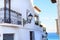 Narrow street of white houses with forged lanterns overlooking the sea in the old town of Altea, Spain on a hot sunny