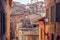 Narrow streets with historical houses of Siena, Tuscany. Tile roofs and brick structures in Italy. UNESCO Site