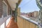 Narrow terrace balcony for access to homes with metal railing and green extendable curtains