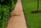 A narrow trail of natural orange and yellow bark leads along the glass building and pebble mulch. Lawns around.