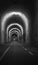 Narrow tunnel with light, monochrome. Empty tunnel with illumination, black and white. Travel destinations concept.