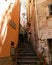 Narrow uphill flight of steps between old houses in Riomaggiore, Italy, full of warm sunshine