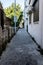 A narrow urban street with stone floors and old vintage buildings