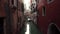 Narrow Venice street with lone boat. Scenic view of Venice canal with old houses