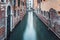 Narrow water canal and red brick worn out buidings built on water in Venice, Italy. Long exposure photography
