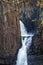 Narrow waterfall with basaltic columns, long shot