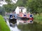 Narrowboat cruising past cottage moorings