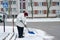 Narva, Estonia. December 23, 2020 Old woman shovels snow