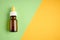 Nasal drops bottle composition, glass bottle on yellow and green background
