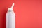 Nasal spray bottle composition, white template bottle on pink background
