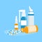 Nasal and throat sprays and open jar of pills on a blue background