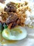 Nasi bungkus mix rice indonesian cuisine food. rice with fried chicken heart and lungs, chili sauce sambal, cucumber and lemon