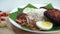 Nasi Lemak dish with chicken drum stick in slow motion