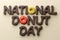 National donut day inscription with donuts with colorful icings instead o letters.