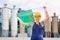 National flag of Algeria in the hands of girl in overalls against background of modern metallurgical plant