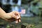 National flag of America on wooden stick. Young man holds state symbol and in the background water flows in river basin. Banner of