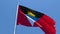 The national flag of Antigua Barbuda is flying in the wind against a blue sky