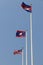 National flag of Cambodia, Laos and Malaysia on bright blue sky background. Blown away by wind.