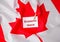 The National Flag of Canada. Canadian Flag with the Maple Leaf and paper note message text ECONOMIC SHOCK. global hunger