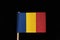 A national flag of Chad on toothpick on black background. A vertical tricolor of blue, gold and red.