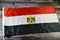 The national flag of Egypt, a tricolour consisting of the three equal horizontal red, white, and black bands, The flag bears Egypt