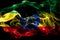 National flag of Ethiopia made from colored smoke isolated on black background. Abstract silky wave background.