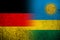 The national flag of Germany with the Republic of Rwanda National flag. Grunge background