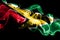 National flag of Guyana made from colored smoke isolated on black background. Abstract silky wave background