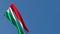 The national flag of Hungary is flying in the wind against the sky