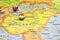 National flag Hungary pinned on political Europe map. Macro Close up picture on a colorful and blurry world atlas with