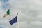 National flag of Ireland and Euro Union flag against cloudy sky background