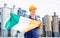 National flag of Ireland in the hands of girl in overalls against background of modern metallurgical plant