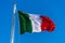 National flag of Italy waving in the wind over blue sky