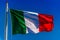 National flag of Italy waving in the wind over blue sky