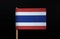 The national flag of the Kingdom of Thailand on toothpick on black background. Five horizontal stripes of red, white, blue, white