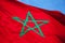 National flag of Morocco above blue sky