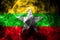 National flag of Myanmar made from colored smoke on black background. Abstract silky wave background.