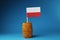 A national flag of poland on wooden stick in wooden barrel