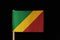 A national flag of the Republic of the Congo on toothpick on black background. Consists of a diagonal tricolour of green, yellow a